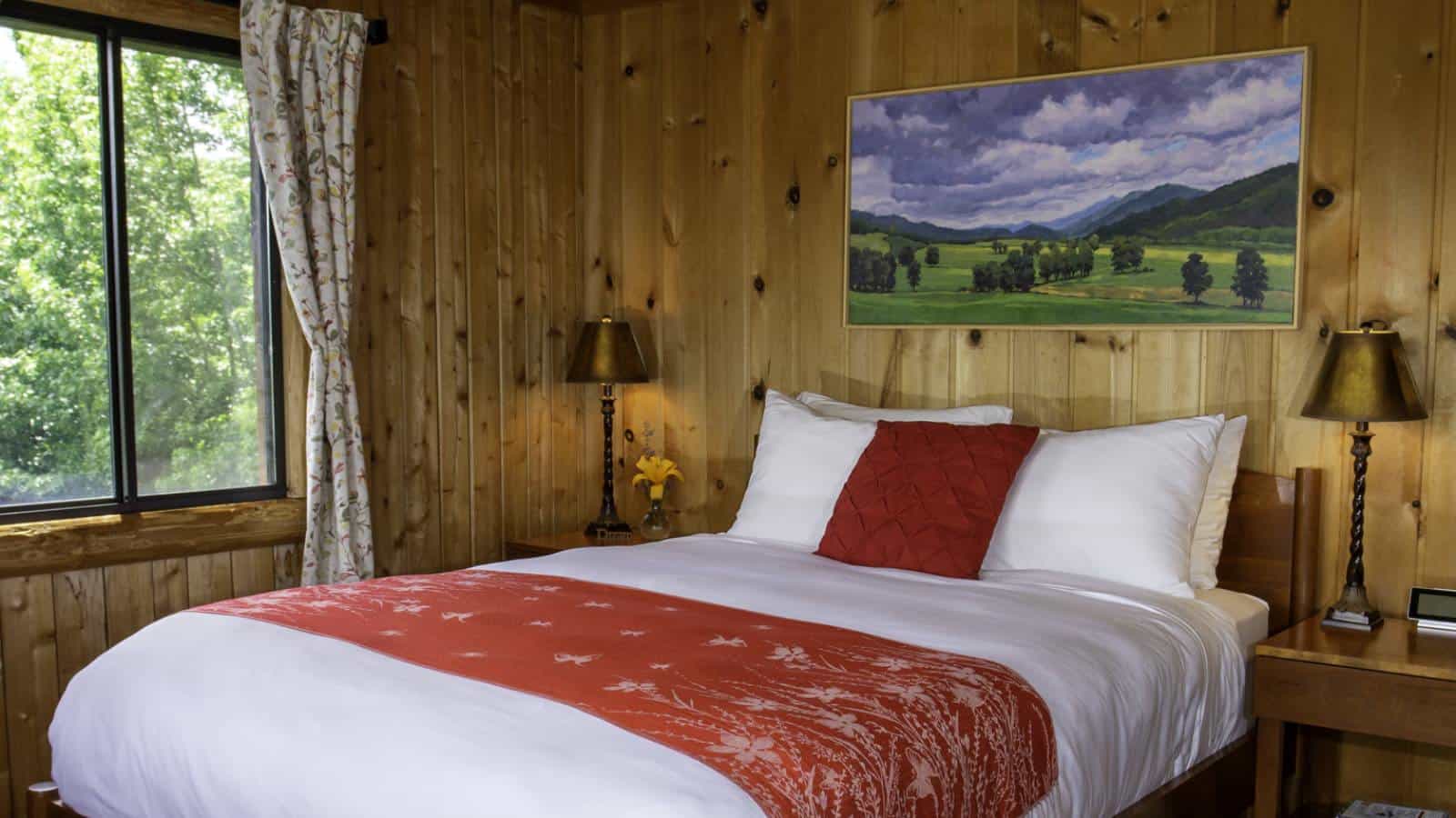 Bedroom with wood paneling, wood bed, white bedding, and wooden nightstands with lamps