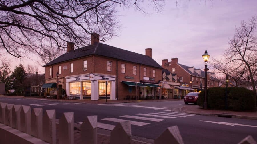 Exterior view of property with brown brick and light trim in a historic downtown area at dusk